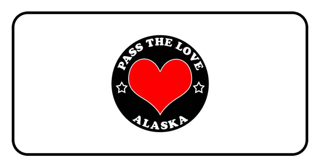 Black circular badge with PASS THE LOVE ALASKA text and red heart for paid cards clothing