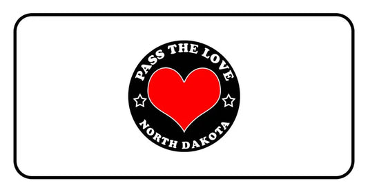 Black badge with red heart and text Pass The Love North Dakota on paid cards