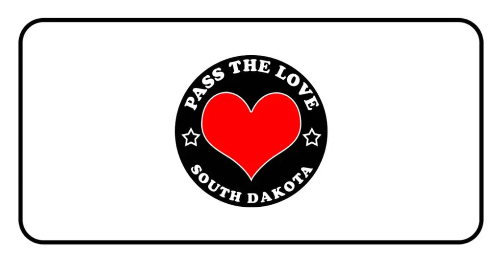 Black badge with red heart and text Pass The Love South Dakota for paid cards